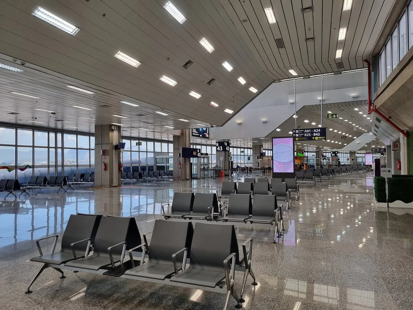 Bright, modern boarding area inside Galeão with gate seating, signage, and passengers waiting to board flights.