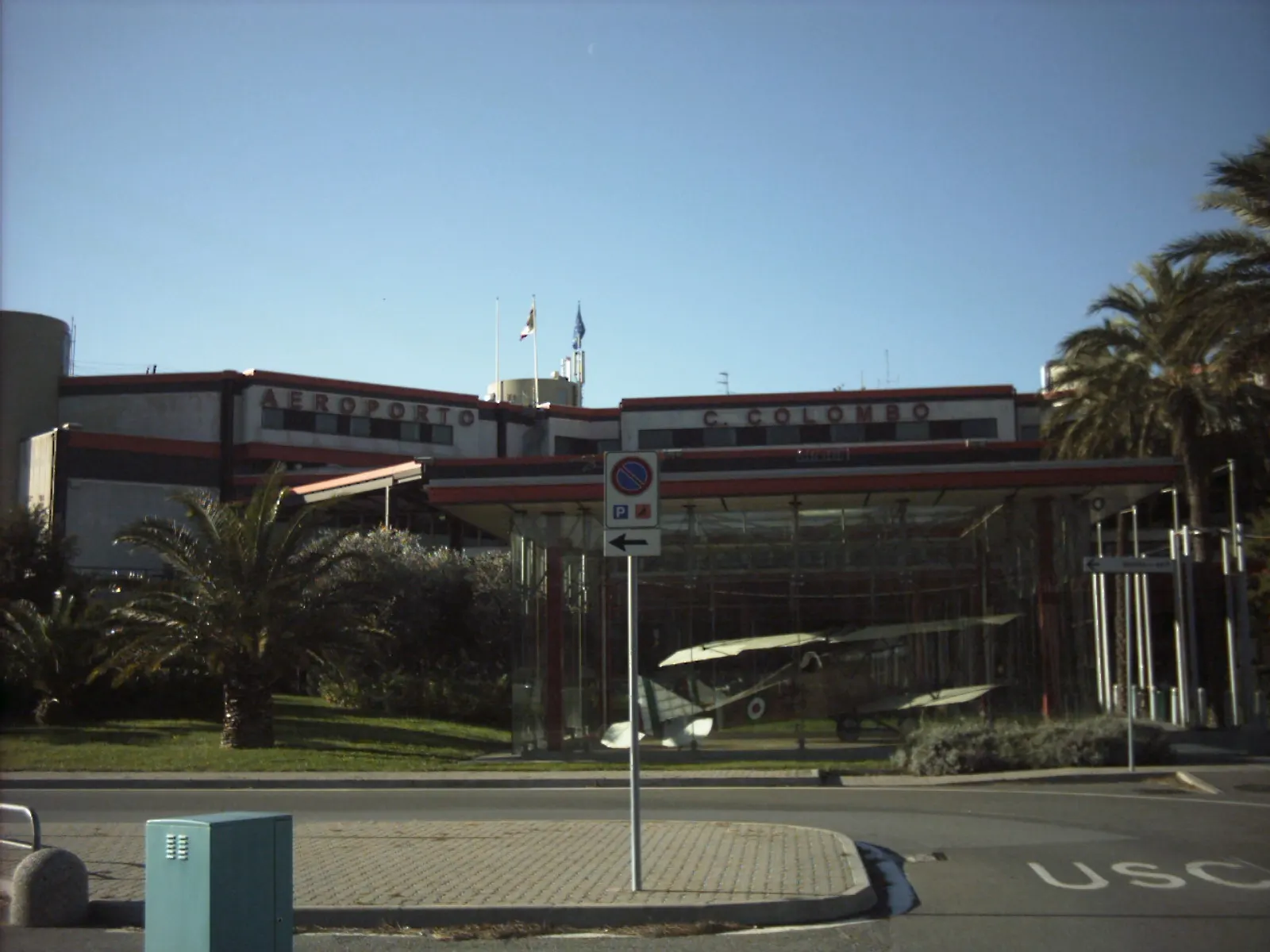 Landside façade of Genoa Cristoforo Colombo Airport with historic biplane display and AEROPORTO C. COLOMBO lettering