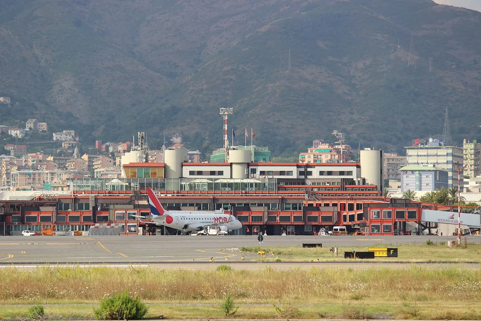 Airside face of Genoa Cristoforo Colombo Airport terminal with mountains of Sestri Ponente behind