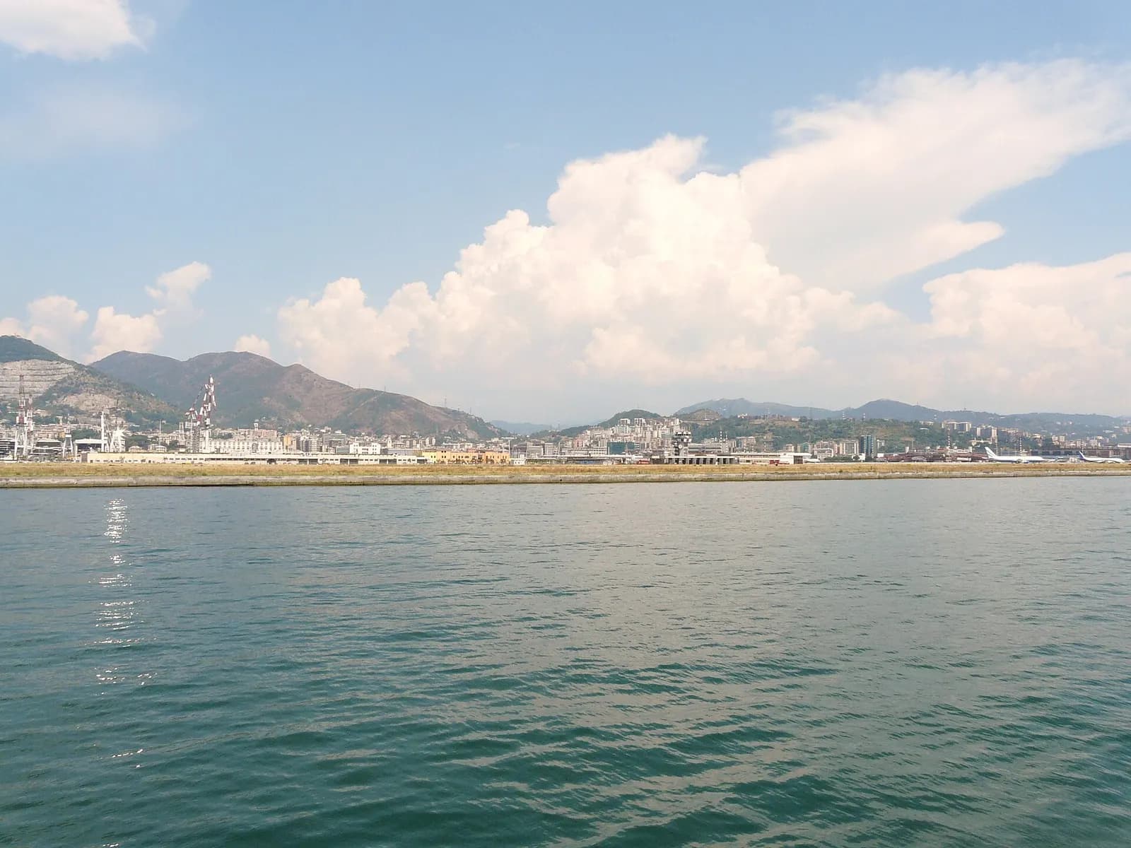 Runway and breakwater of Genoa Cristoforo Colombo Airport photographed from the sea