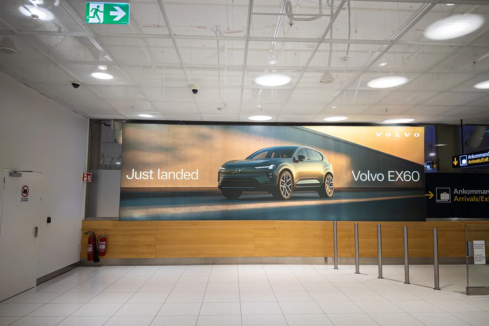 An advertisement for the 2027 Volvo EX60 SUV is displayed in the arrivals hall of Gothenburg Landvetter Airport in Härryda, Sweden, on February 14, 2026.