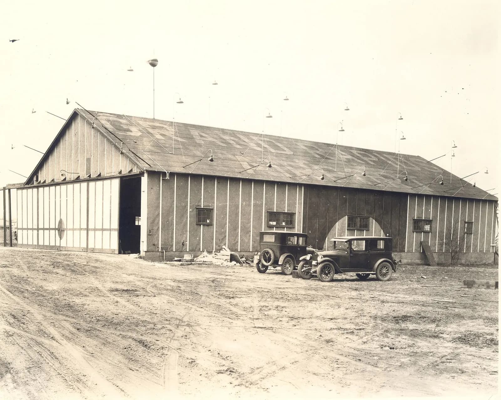 1930 hangar at Grand Rapids Airport with two parked cars in front of the building.