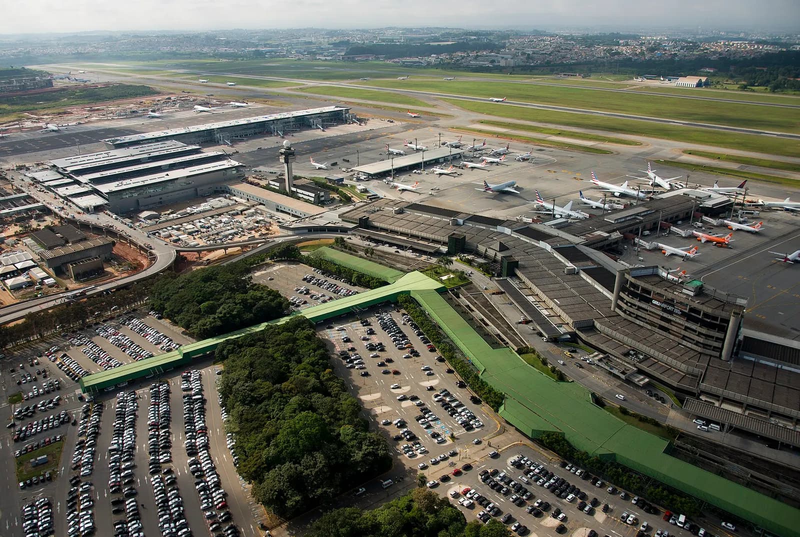 Aerial photograph of São Paulo-Guarulhos International Airport showing parallel runways, terminal buildings, and the surrounding Guarulhos area.