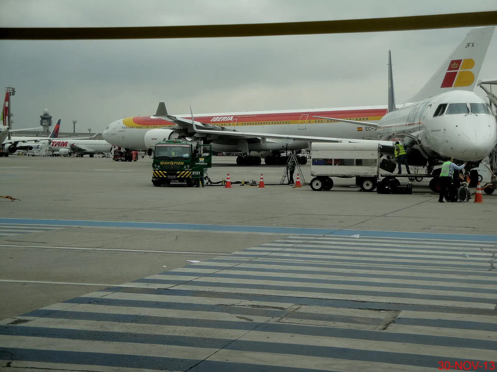 Passengers walking across the open ramp to board aircraft at Terminal 4, which has no jet bridges.