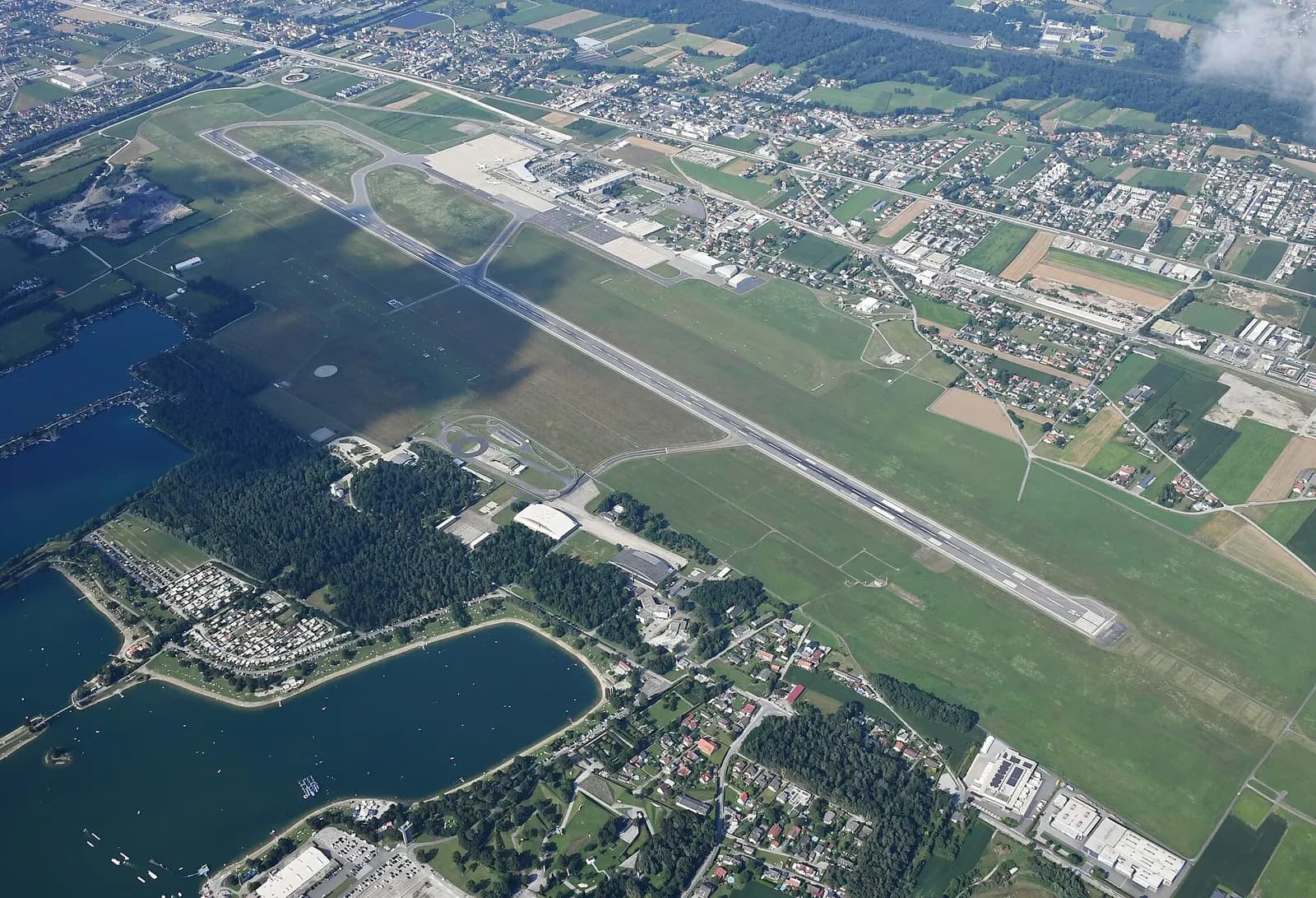 Aerial view of Graz Airport runway 16/34, terminal, and Schwarzlsee to the southwest