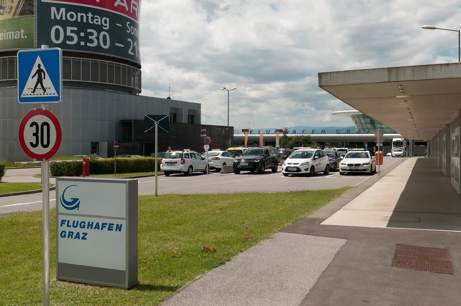 Landside Flughafen Graz sign and taxi curb in front of the passenger terminal