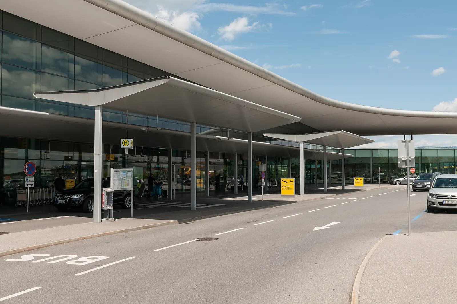 Departures drop-off under the curved white canopy with ABFLUG DEPARTURE signage