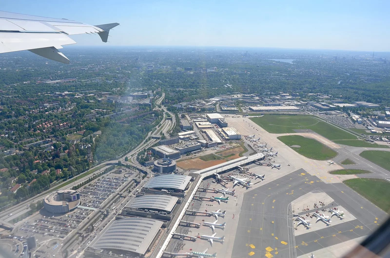 An aerial view of Hamburg Airport runways, terminals, and surrounding Fuhlsbüttel neighborhood including Zeppelinsstraße.