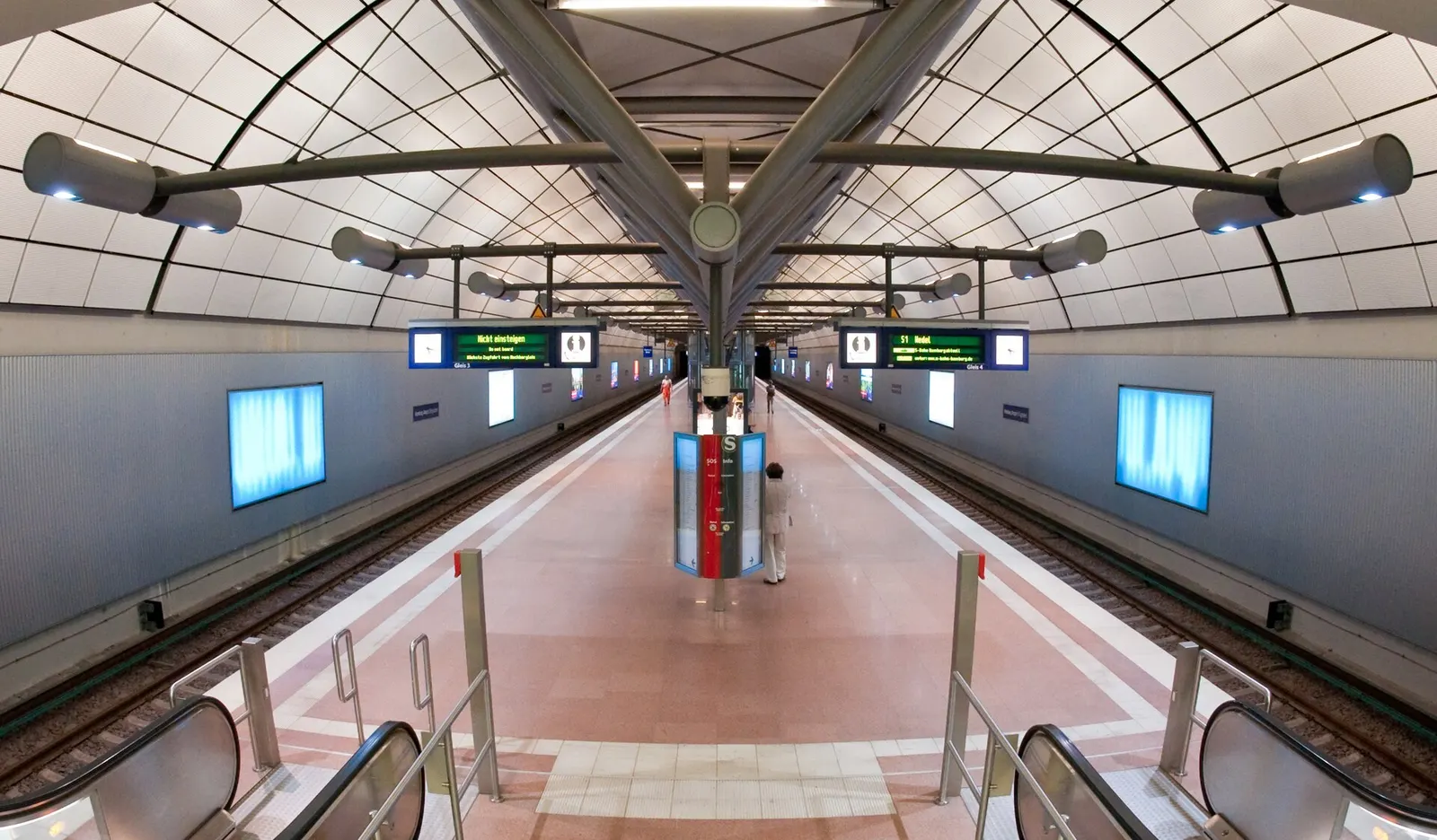 The entrance to the Hamburg Airport S-Bahn station with signage, stairs, and passageways leading to the rail platforms.
