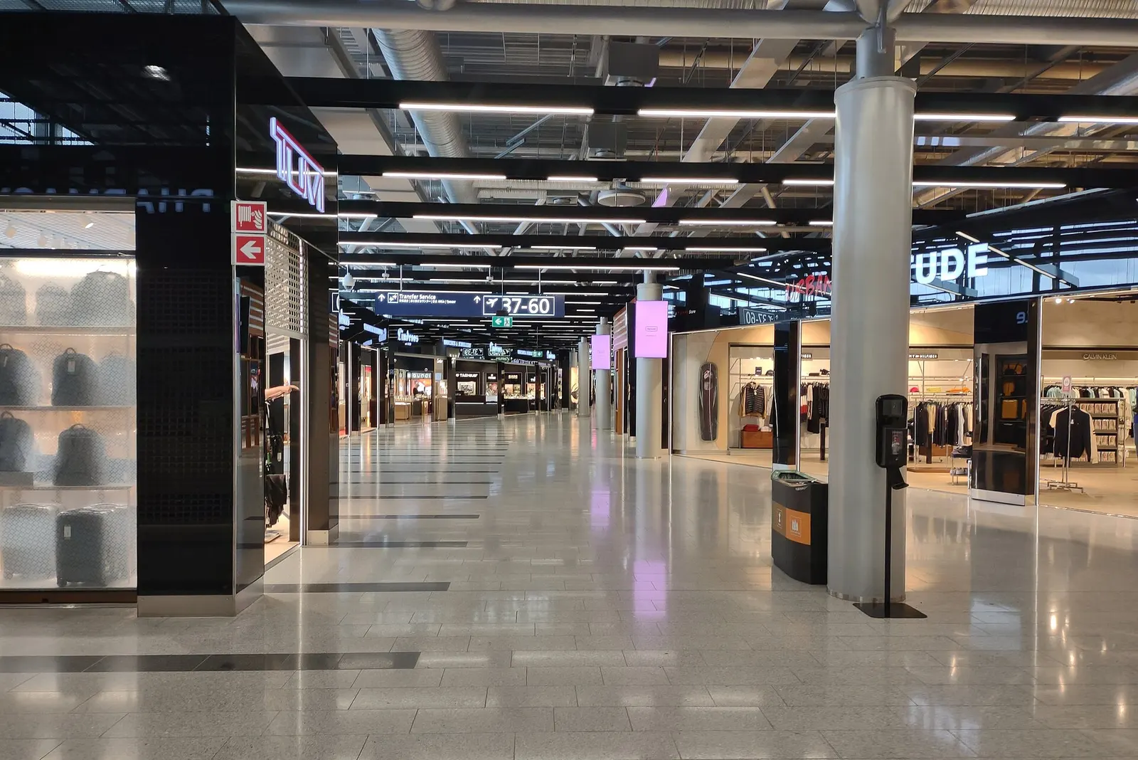 Bright, spacious non-Schengen concourse in Terminal 2 with wooden accents, seating areas, and departure gate signage.