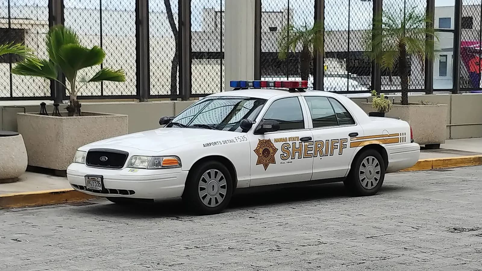 Ford Crown Victoria Police Interceptor of the Hawaii State Sheriff Division at the Daniel K. Inouye International Airport in 2021. This car is specifically assigned to the Airport Detail.