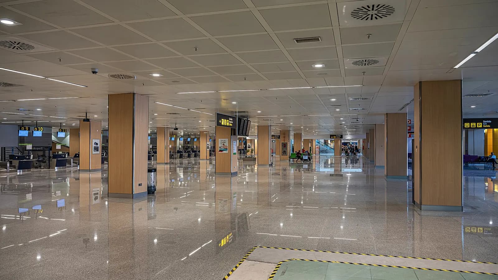 Interior public hall of Ibiza Airport with passengers and check-in area.