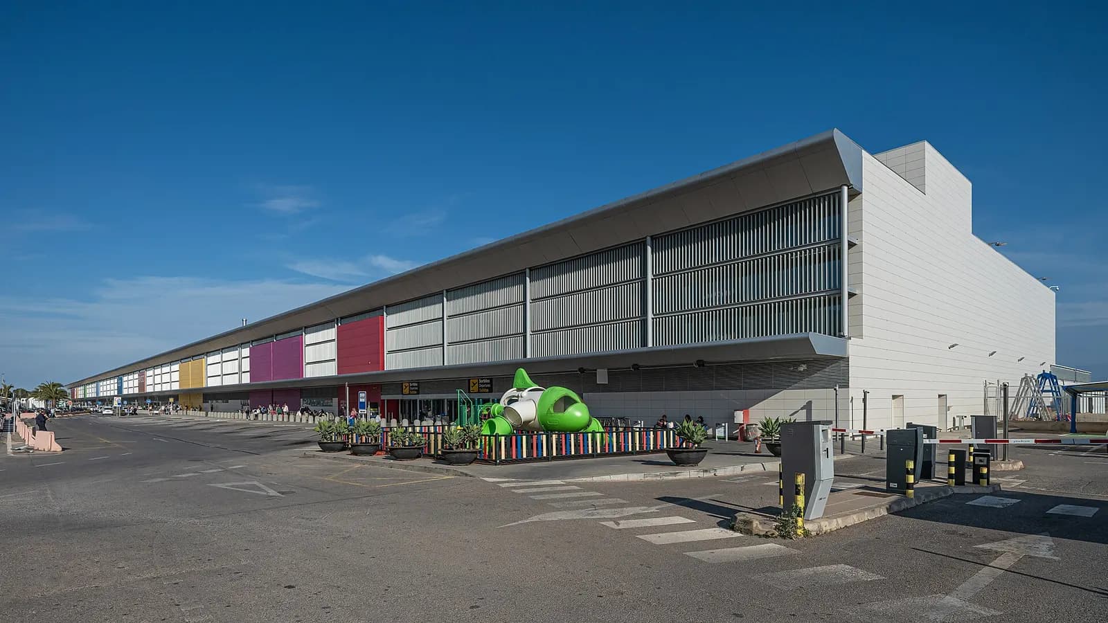 Daytime exterior of Ibiza Airport’s passenger terminal and landside forecourt.