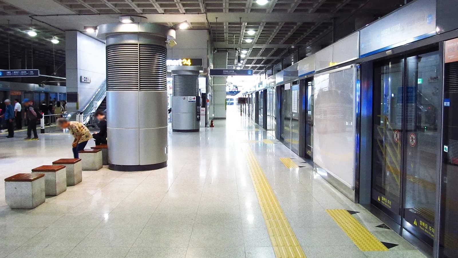 The AREX commuter train platform at Incheon Airport Terminal 1 Station with tracks, platform screen doors, and station signage.