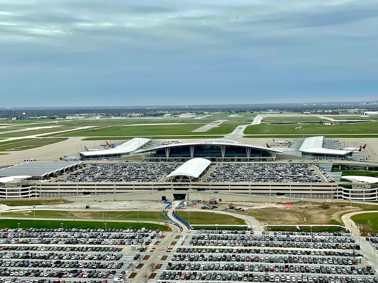 This photo was taken on April 9, 2025 at 11:34 AM, from the Indianapolis International Airport Control tower, giving a view of the parking garage and terminal building.