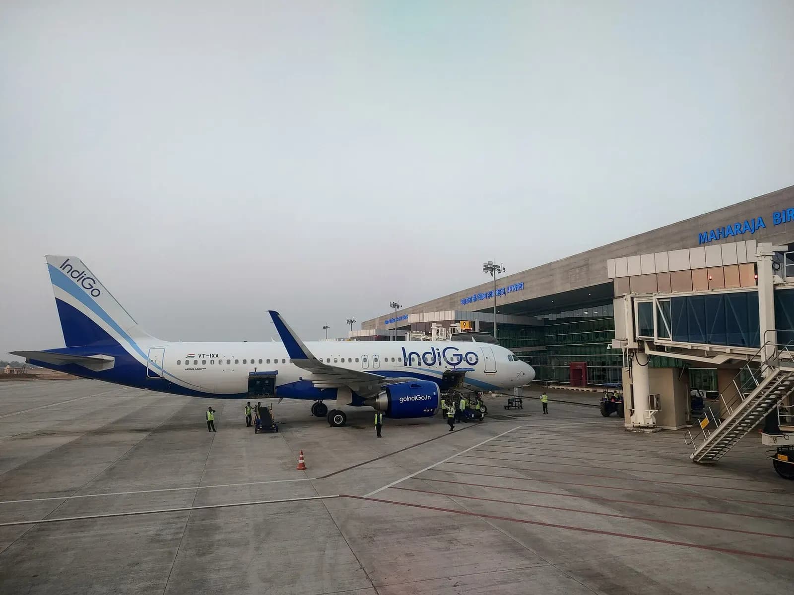 IndiGo Airbus A320neo VT-IXA on the apron at Maharaja Bir Bikram Airport with terminal signage visible behind the aircraft.