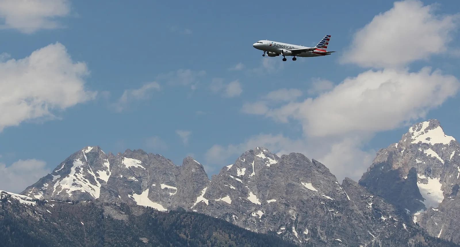 July 2017 American Airlines Airbus A319 on approach to Jackson Hole Airport with the Grand Teton range behind the aircraft.