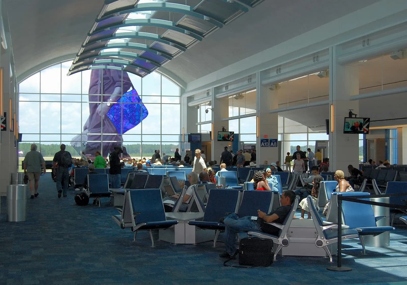 Jacksonville International Airport Concourse A hold room with gates A8–A10 and the blue-bag window art