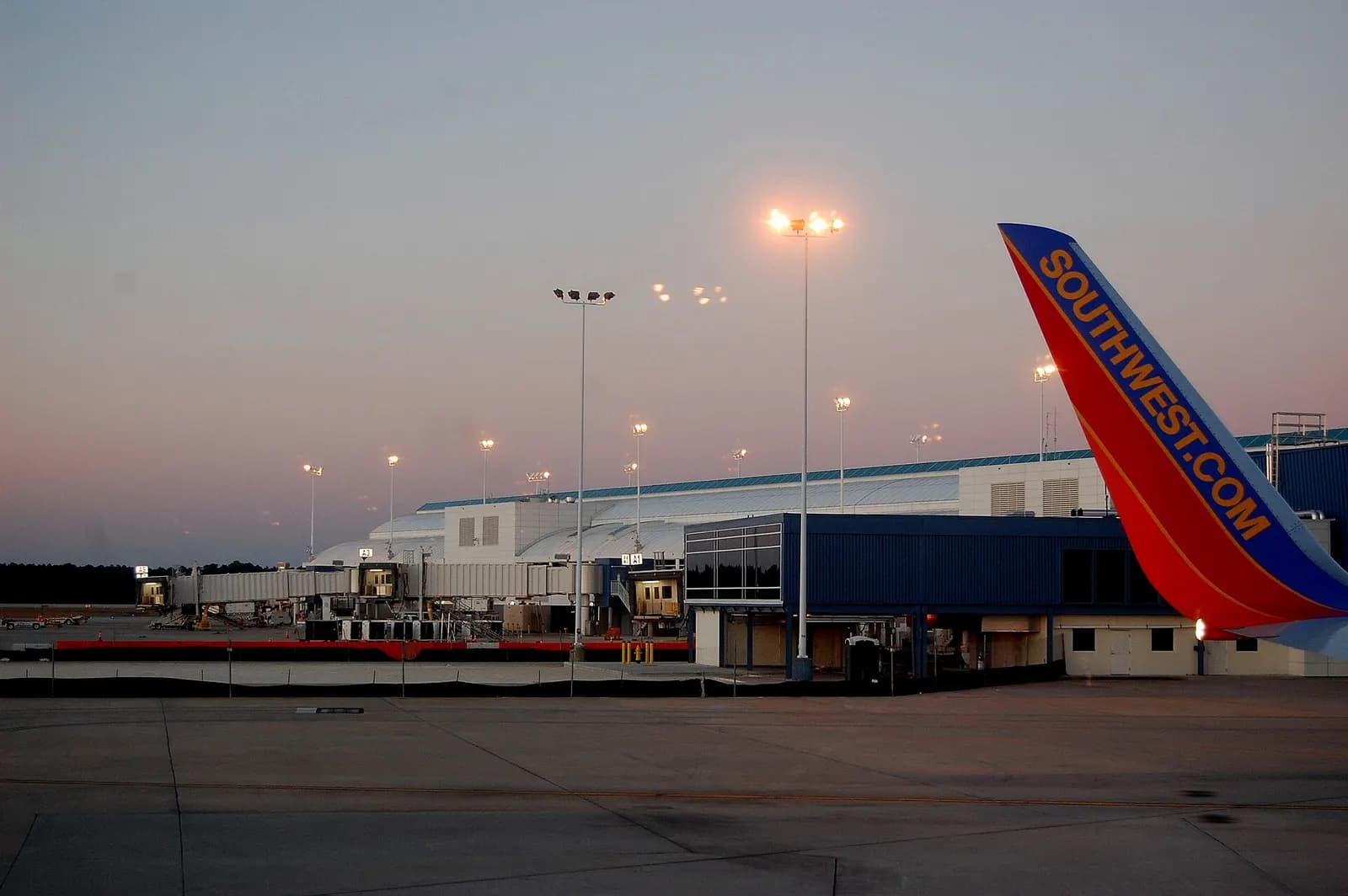 Jacksonville International Airport Concourse A apron at dusk, gates A1–A2 and a Southwest tail