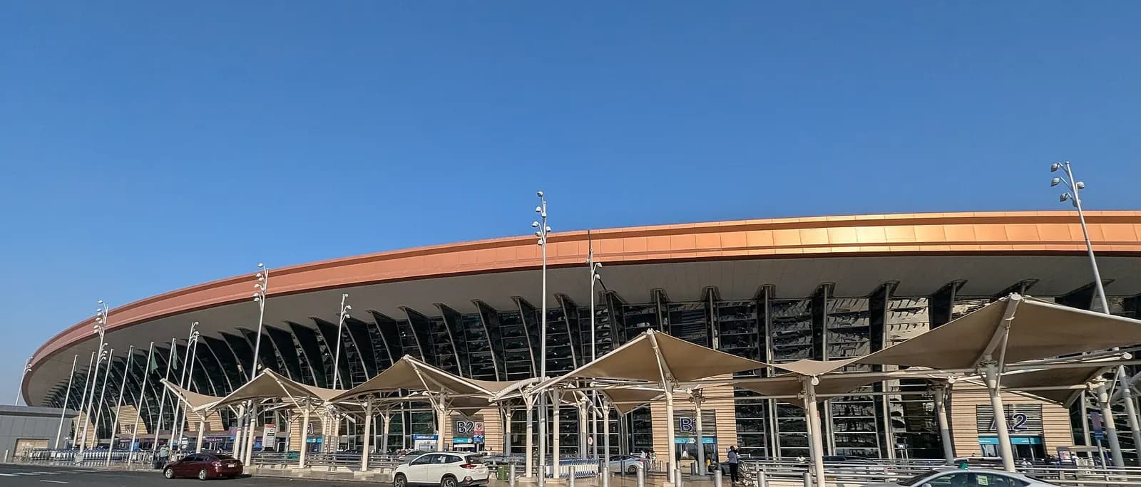 A wide shot captures the entrance gates and forecourt leading into Jeddah Terminal 1.