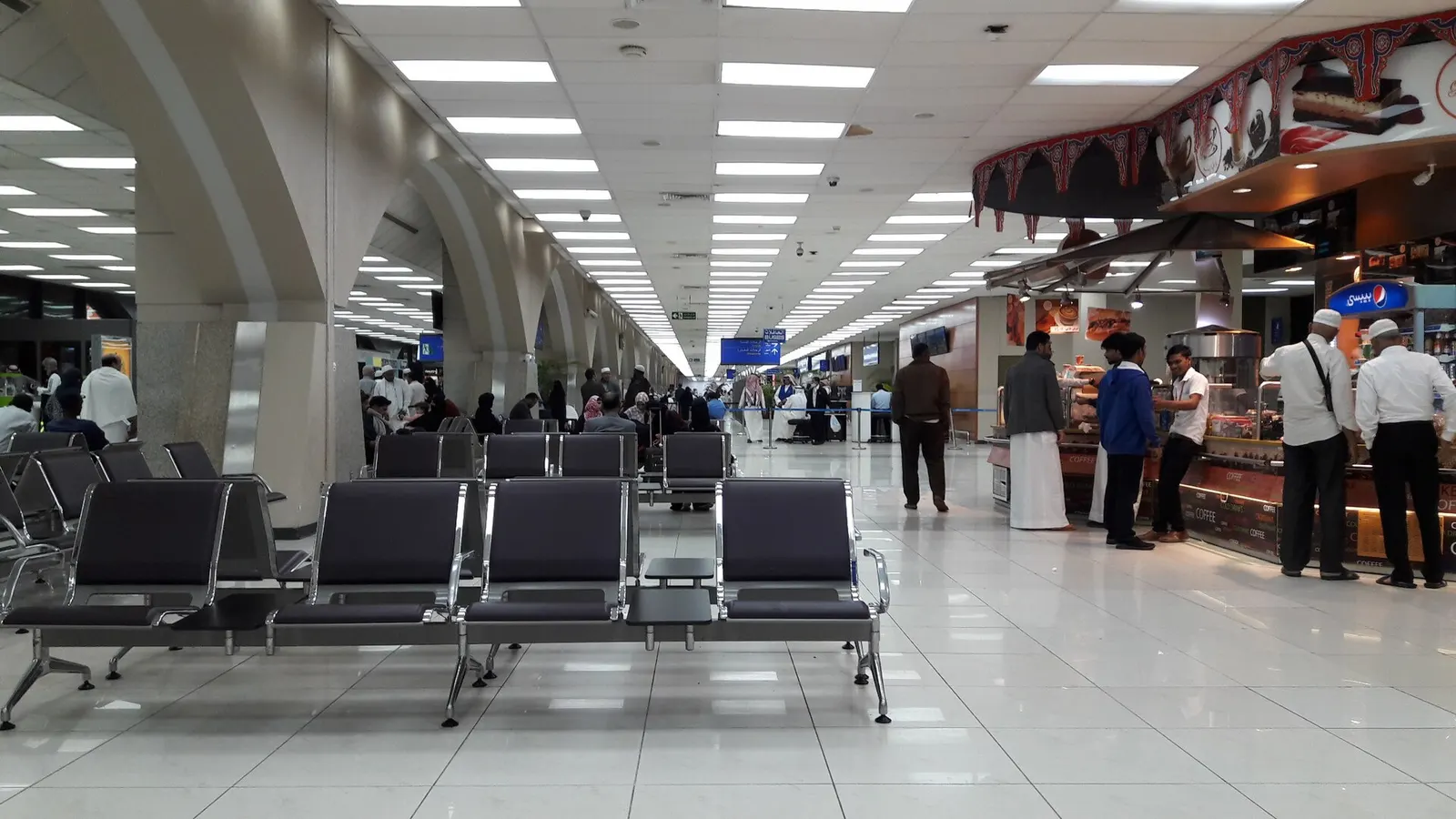 The North Terminal building at King Abdulaziz International Airport is seen from outside, showing its facade and vehicle drop-off area.