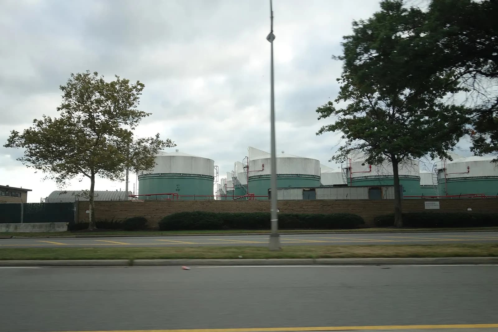 Traveling southeast on the Van Wyck Expressway towards the terminals of John F. Kennedy International Airport, near South Ozone Park, Queens. Pictured is the fuel farm along the south edge of the airport.