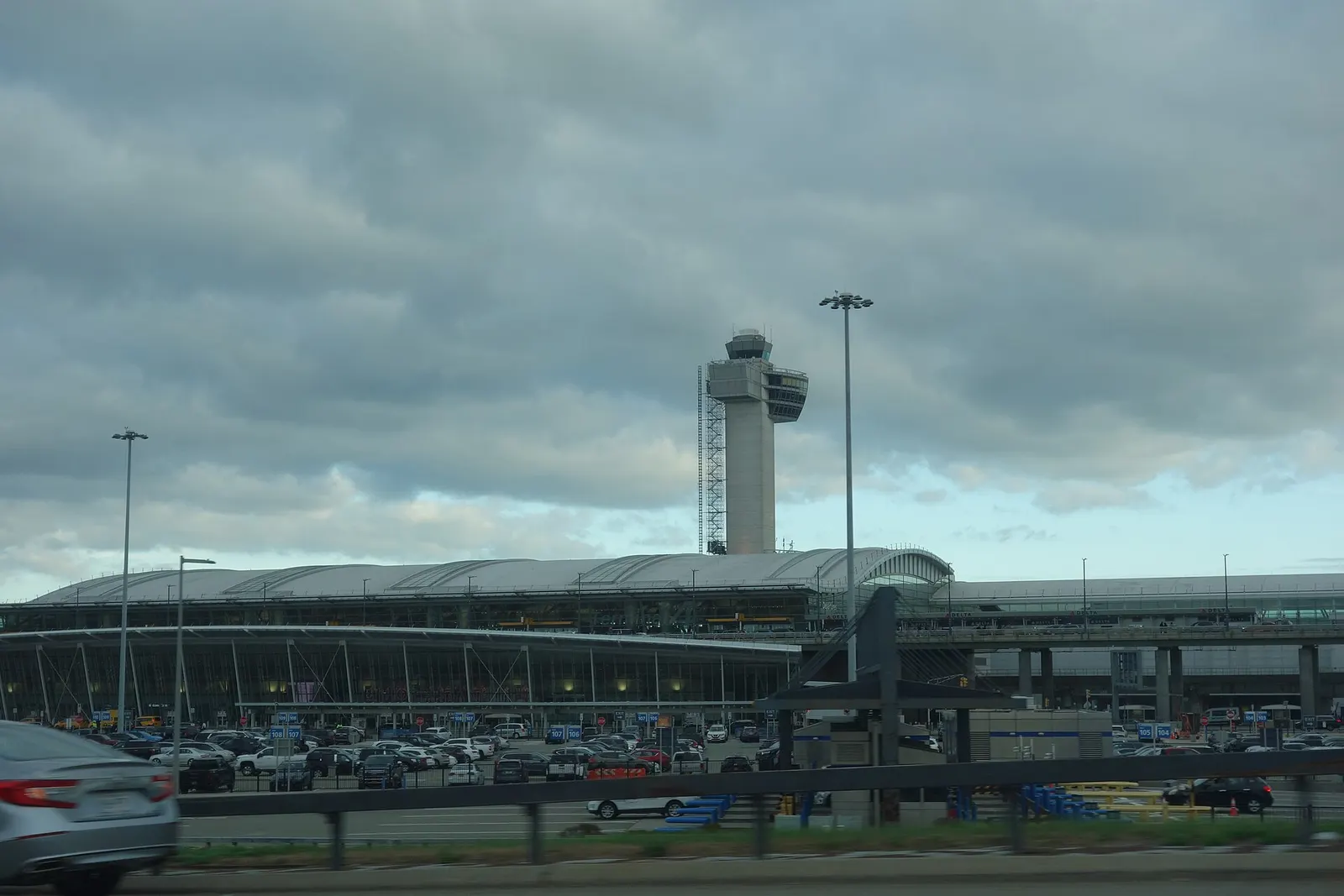 Terminal 4 is visible from the Van Wyck Expressway as cars travel south toward JFK's central terminal area.