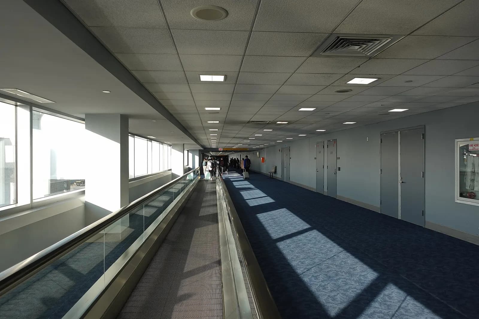 The arrivals area at Terminal 8 features a spacious hall with baggage claim carousels, directional signs, and passengers collecting luggage.