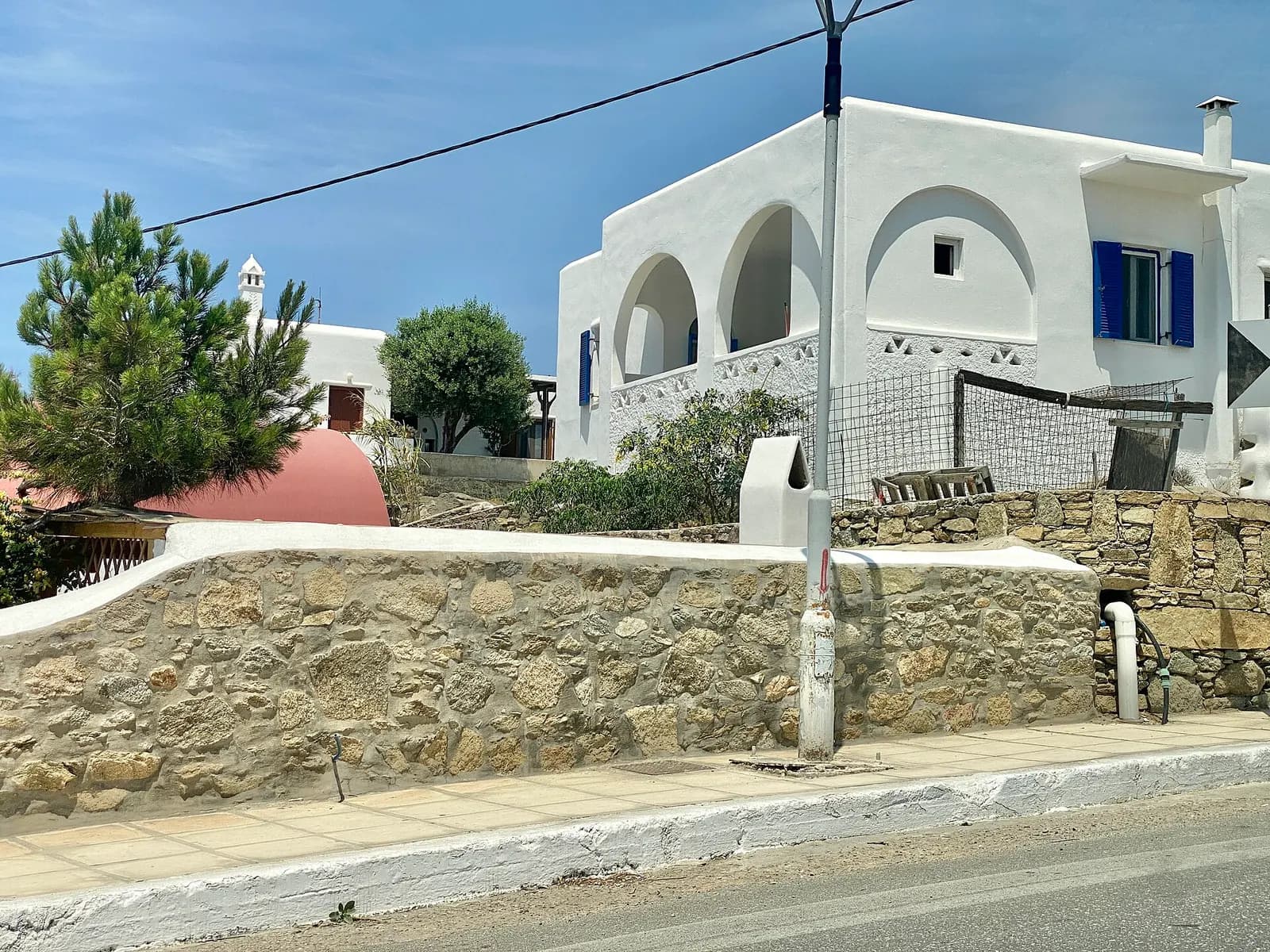 The Cycladic houses of the island of Mykonos take after other islands in the Cyclades, with white stucco exteriors, white or colorful trim, low-slope roofs enclosed by parapets, and casement windows. The islands, one of the most scenic parts of Greece, are known for this style of architecture, which