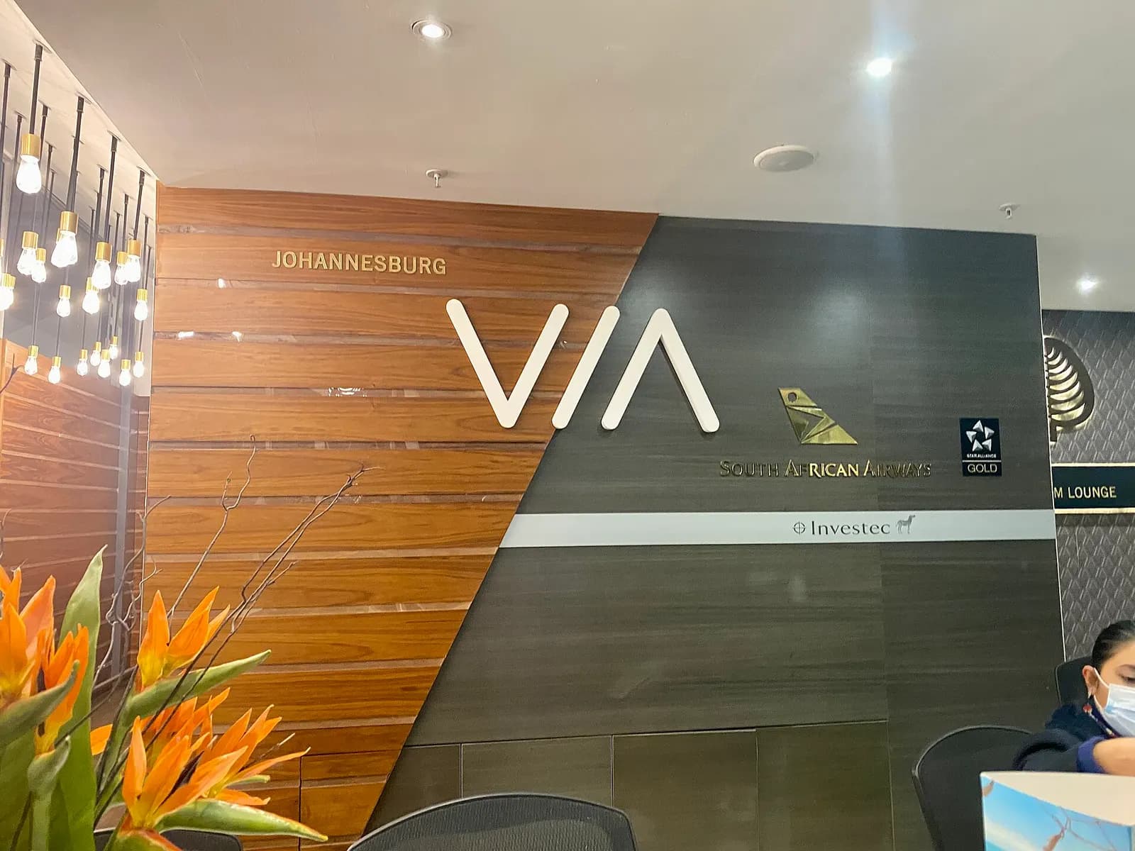 The South African Airways lounge at O.R. Tambo International Airport with seating areas, tables, and large windows overlooking the airfield.