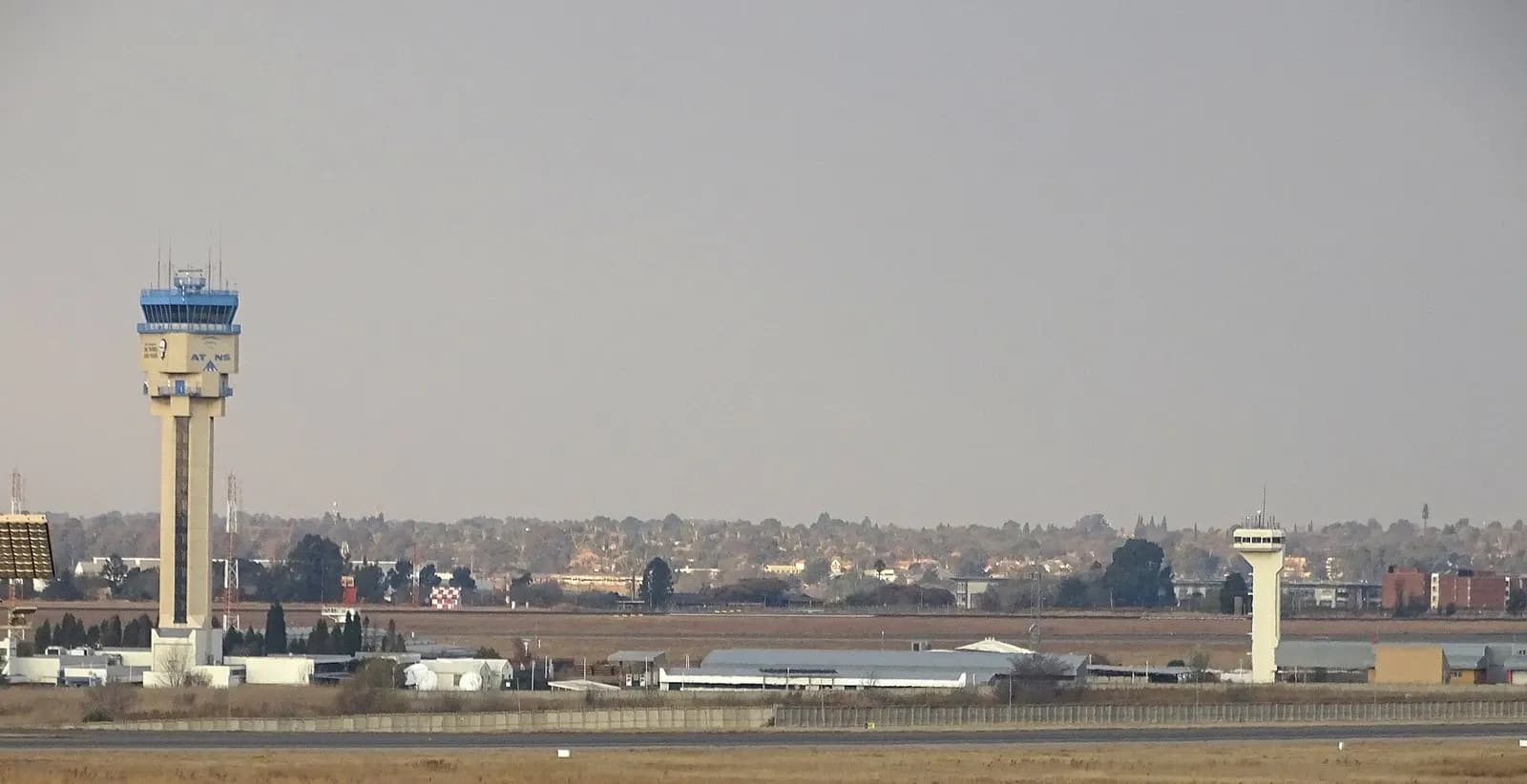The distinctive air traffic control tower at O.R. Tambo International Airport rising above the terminal buildings and apron.