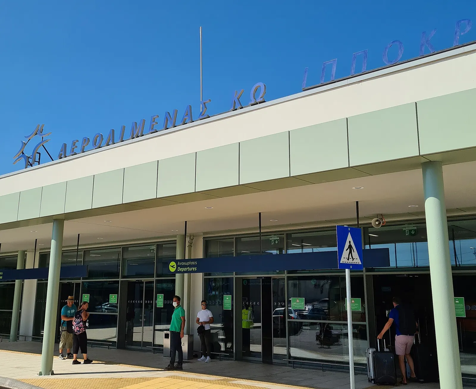 Kos Ippokratis Airport terminal exterior under Fraport Greece branding, 2021.