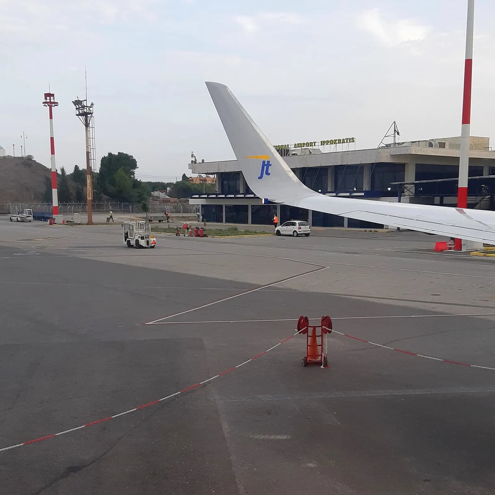 Kos Airport terminal building photographed from a parked aircraft on the apron.