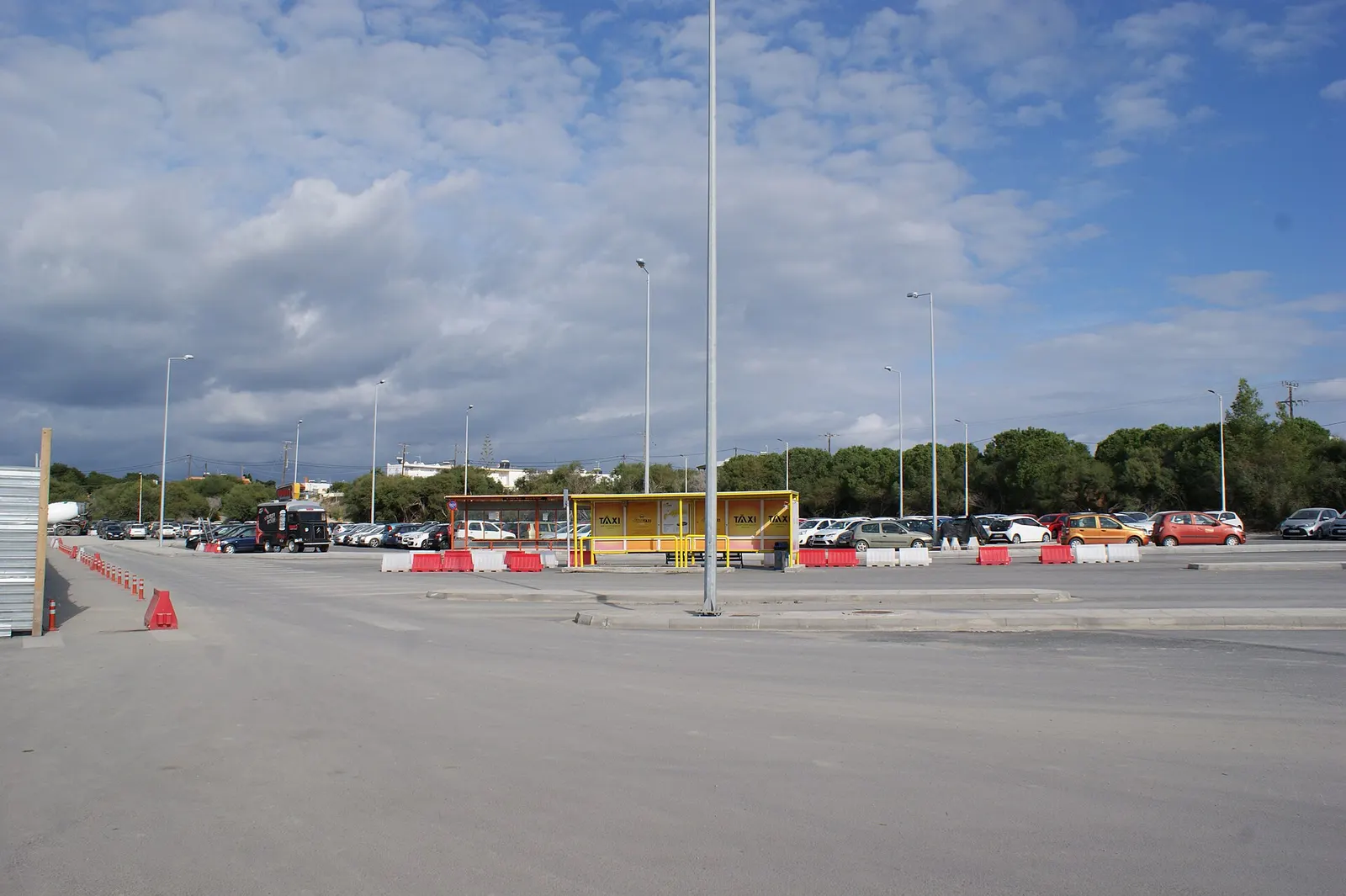 Wide view of Kos Ippokratis Airport terminal campus from the landside approach.