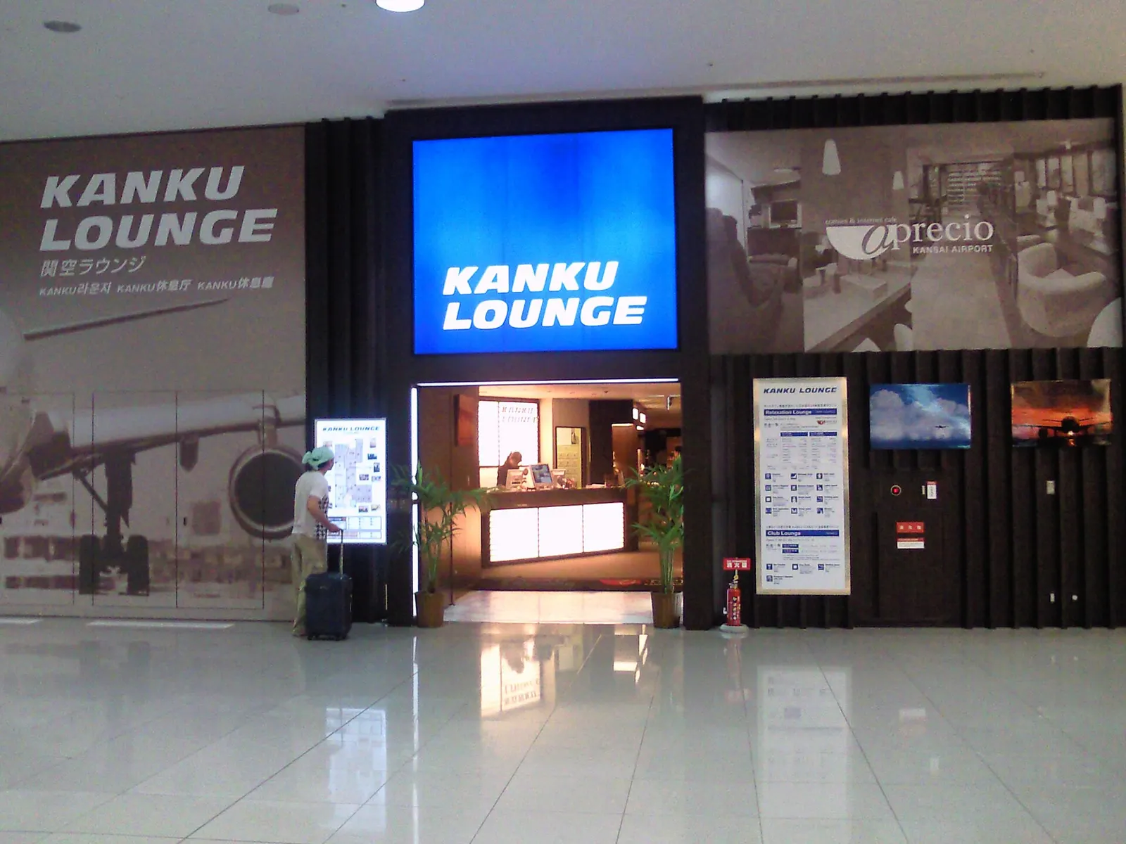 Interior of the Aprecio KIX lounge with seating areas, tables, and refreshments for waiting passengers.