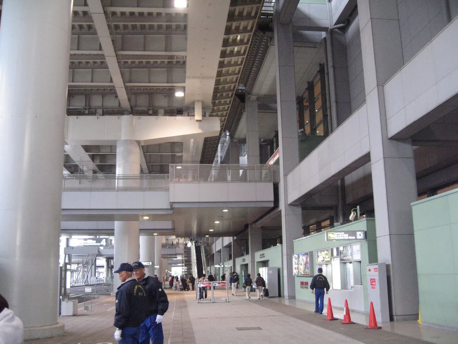 The arrivals hall in Terminal 1 with high ceilings, international signage, and passengers moving through the space.