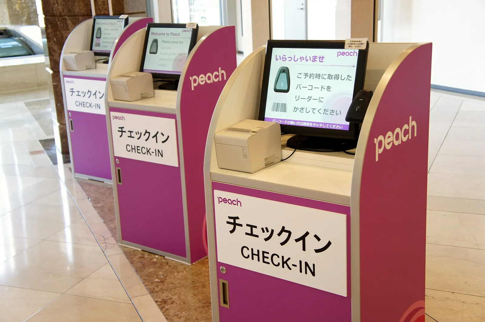 A Peach Aviation self-service check-in kiosk in the Aeroplaza building near the airport terminals.