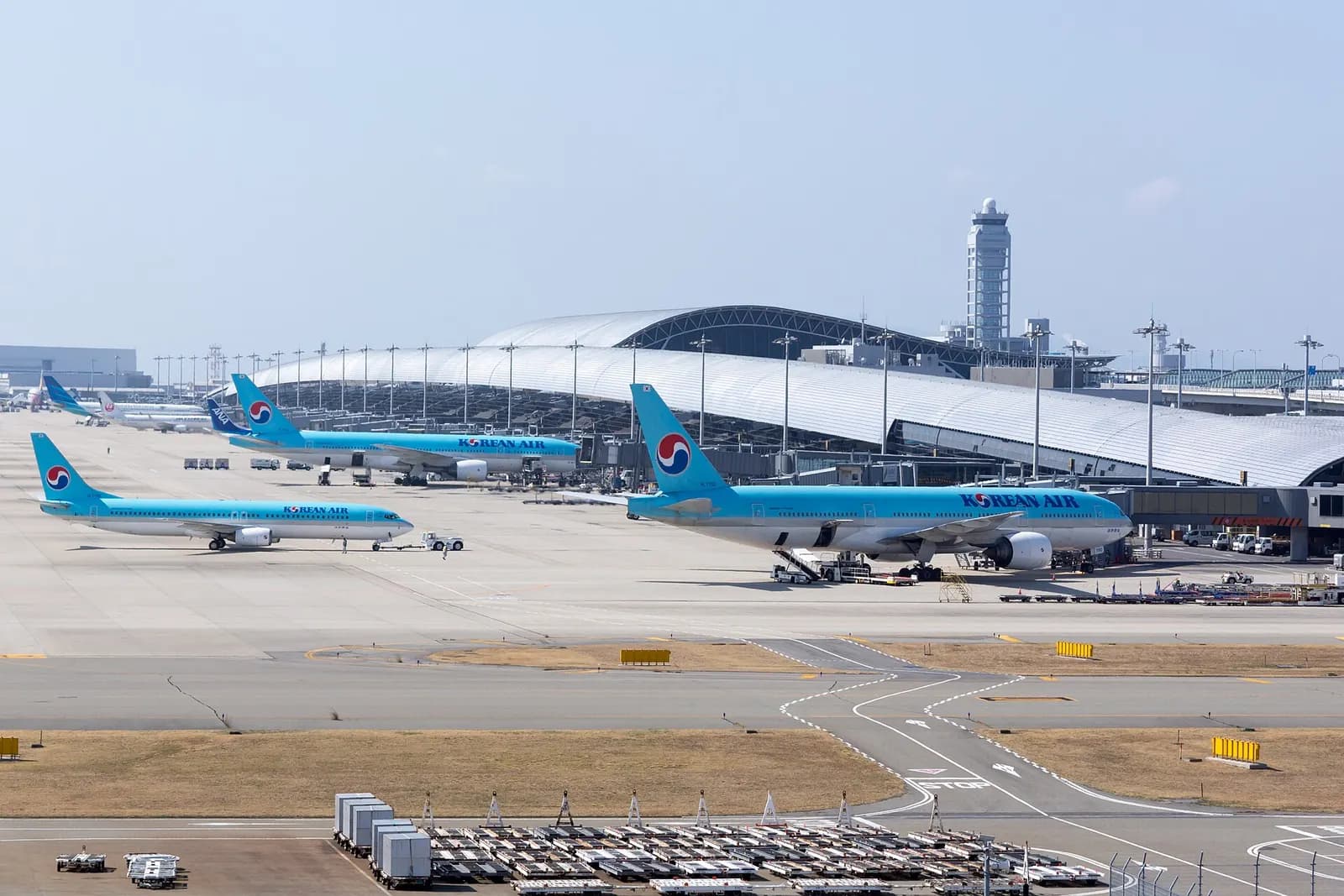 Terminal 1's long curved roof and jet bridges seen from the Sky View observation deck above the airport.