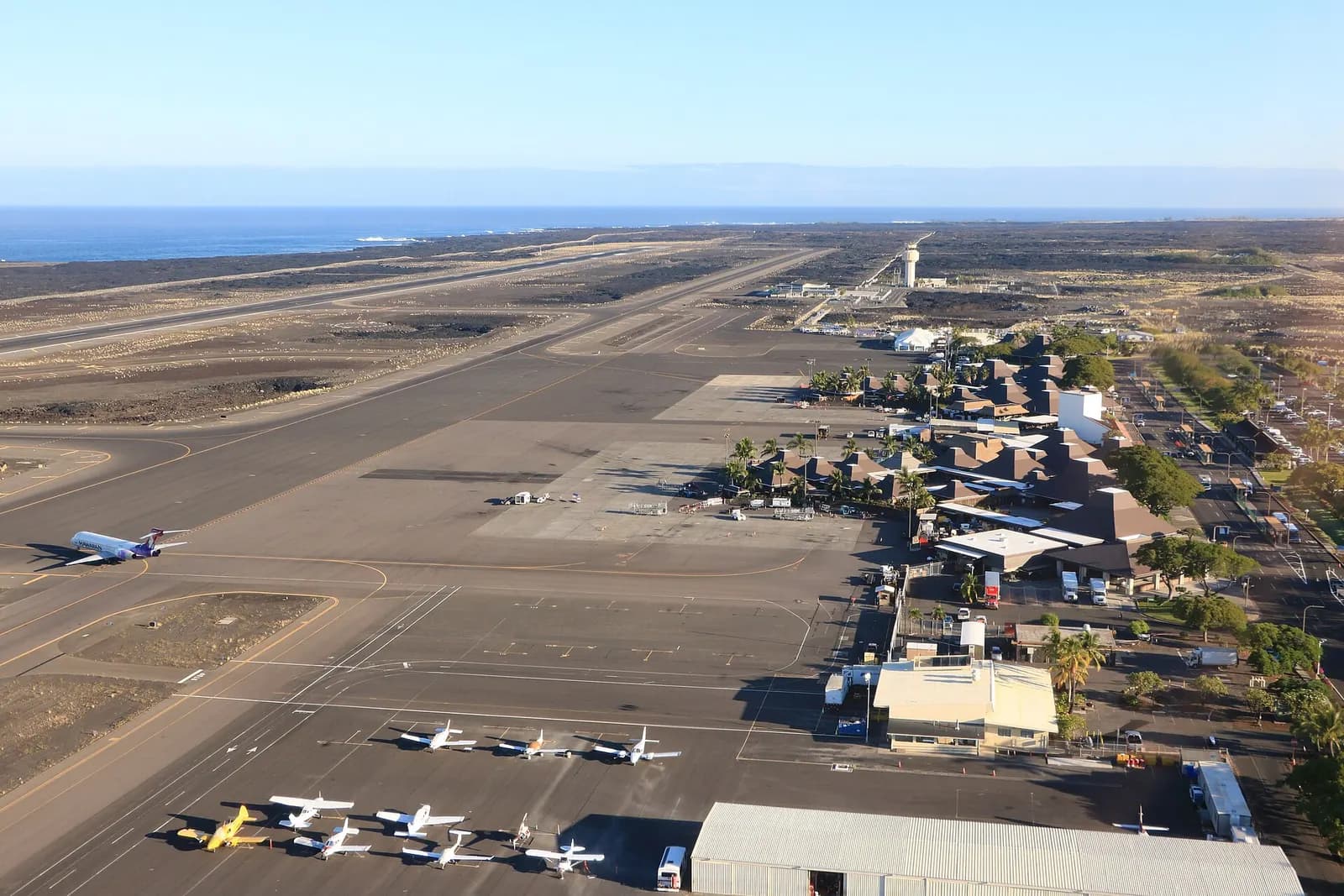 Aerial of Kona’s single 17/35 runway, lava field, and open-air pavilion terminal