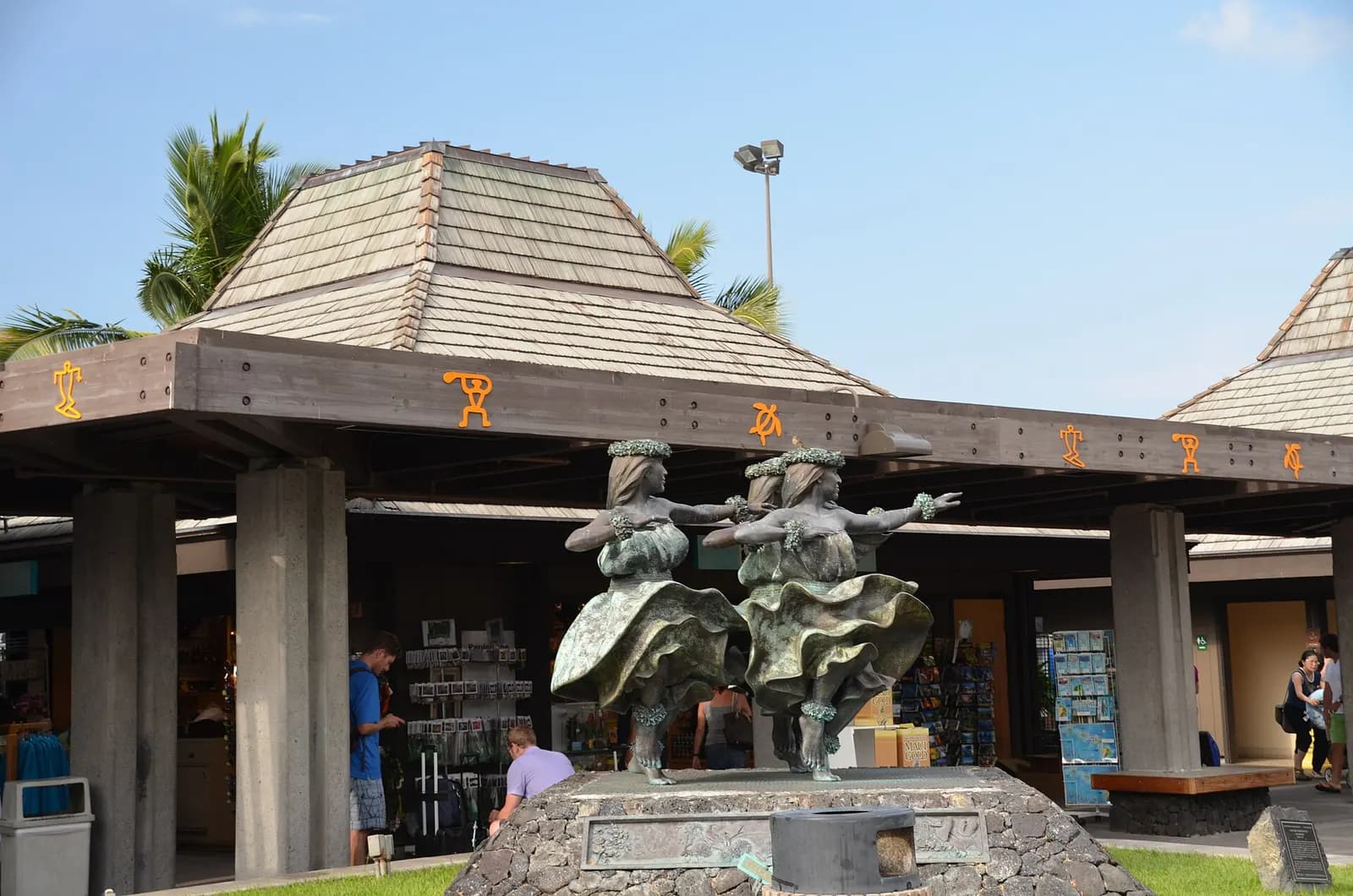 Hula bronze statues in front of an open-air gift pavilion at Kona airport