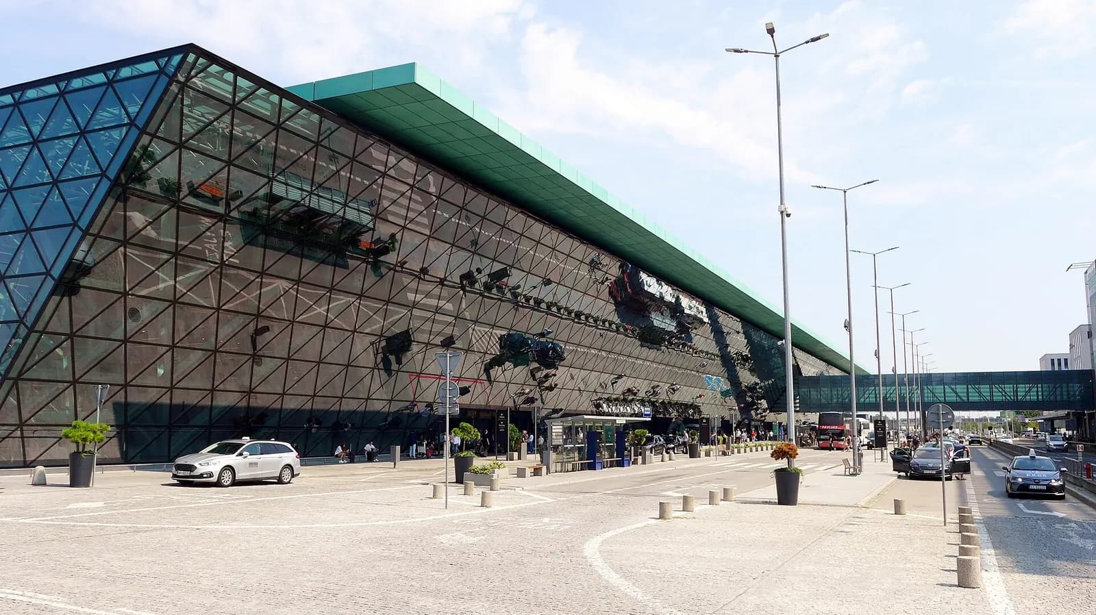 Wide daylight view of the modern passenger terminal building at Kraków John Paul II International Airport.