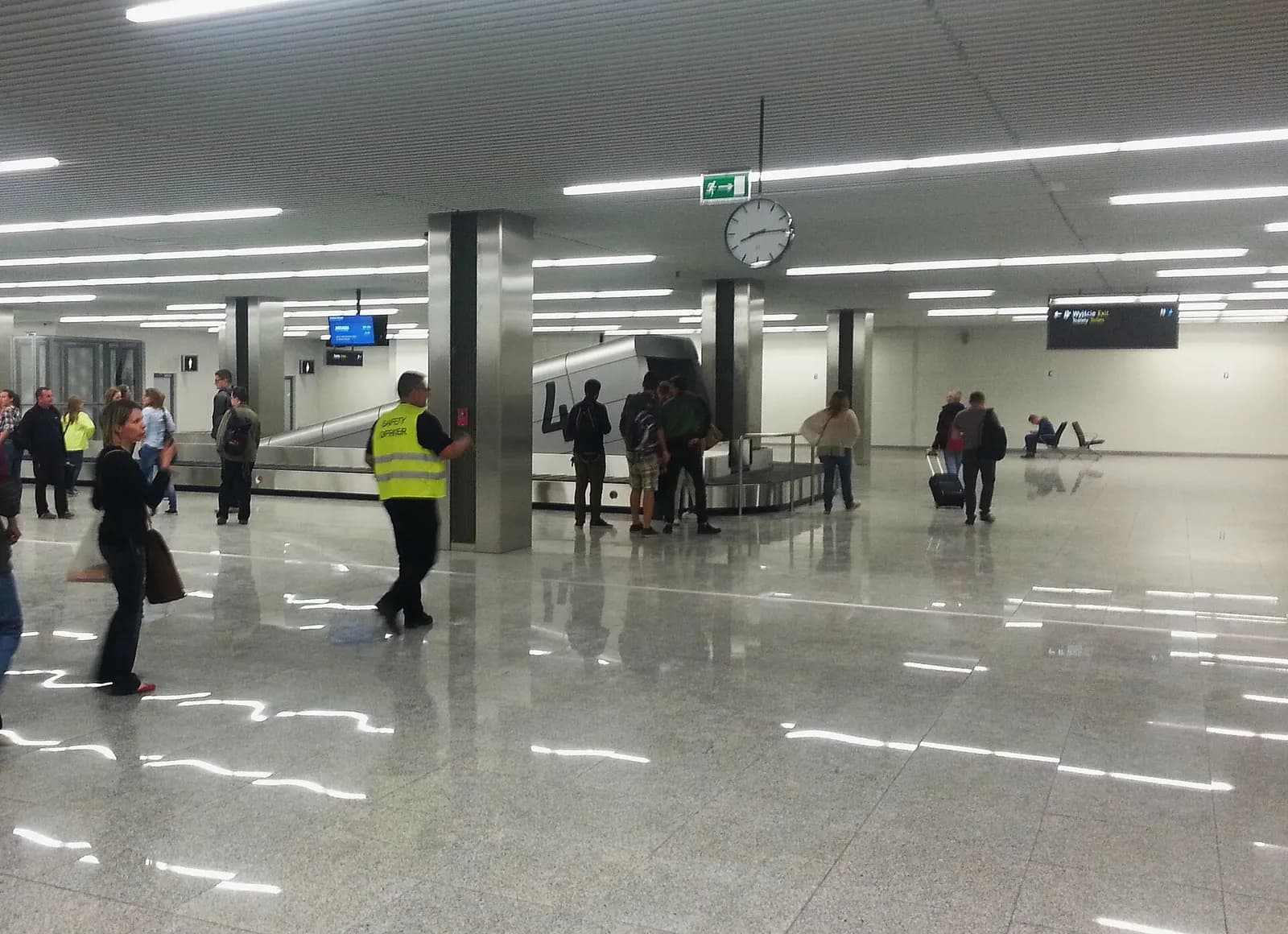 Interior of the arrivals hall at Kraków Airport with the baggage claim and passenger areas visible during a partial opening in 2015.
