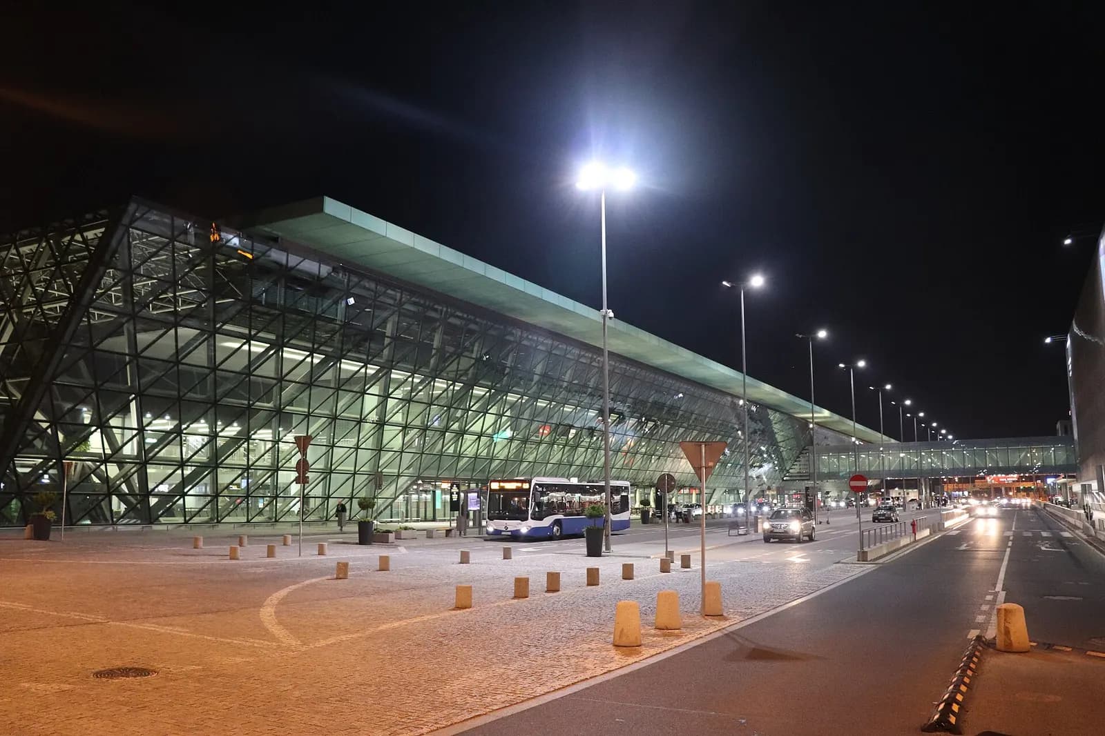The illuminated Kraków-Balice passenger terminal building photographed at night.
