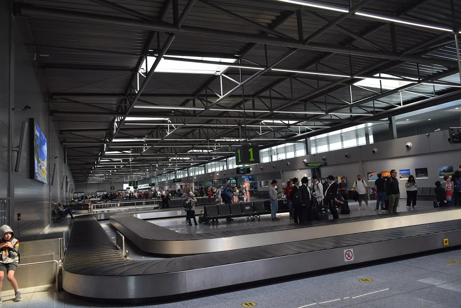 The bright, open passenger hall inside Katowice Airport with seating areas, signage, and travelers moving through the terminal.