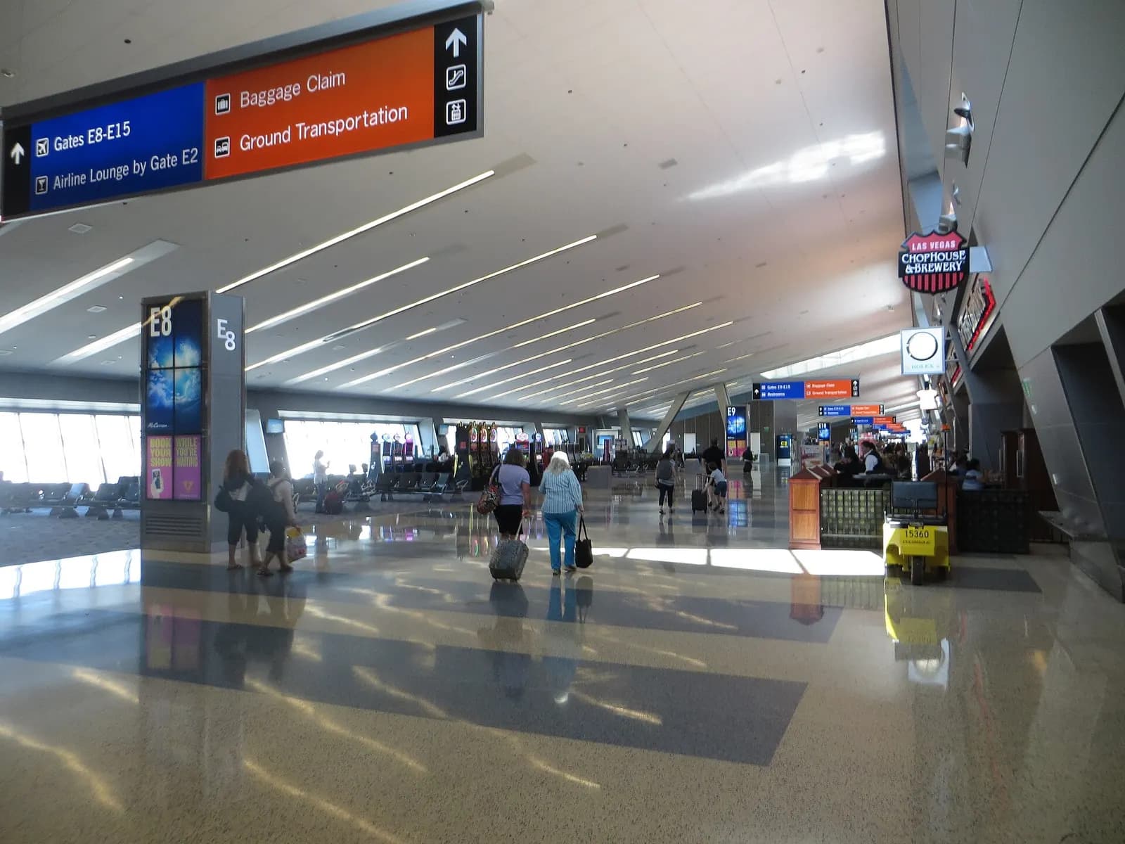 Airside waiting area at Terminal 3 with gate seating, large windows, and parked aircraft visible outside.