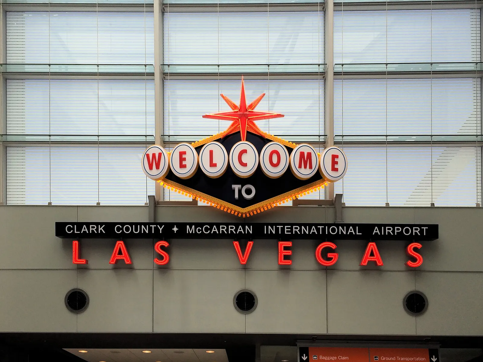The illuminated Welcome to Fabulous Las Vegas sign displayed inside Terminal 3 with travelers passing nearby.