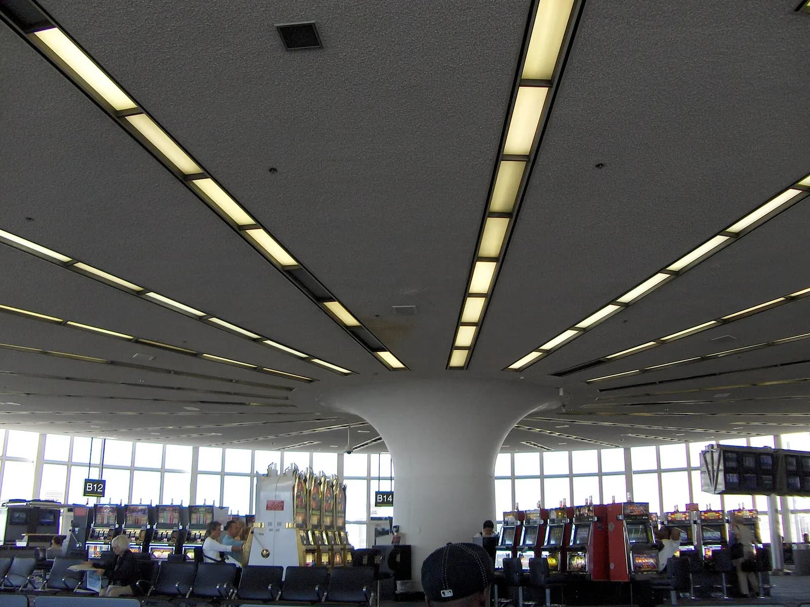 Interior concourse of Terminal B with high ceilings, moving walkways, and gate signage along the hallway.