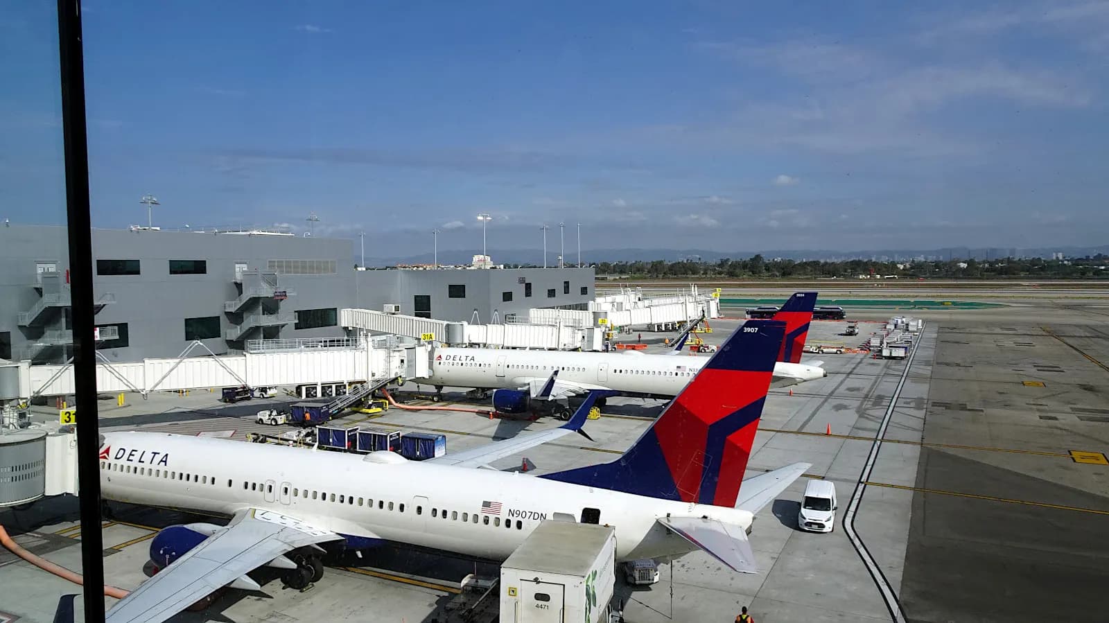 The outdoor Sky Deck at the Delta Sky Club in Terminal 3, overlooking parked airliners and the airport ramp with the terminal roof in the foreground.