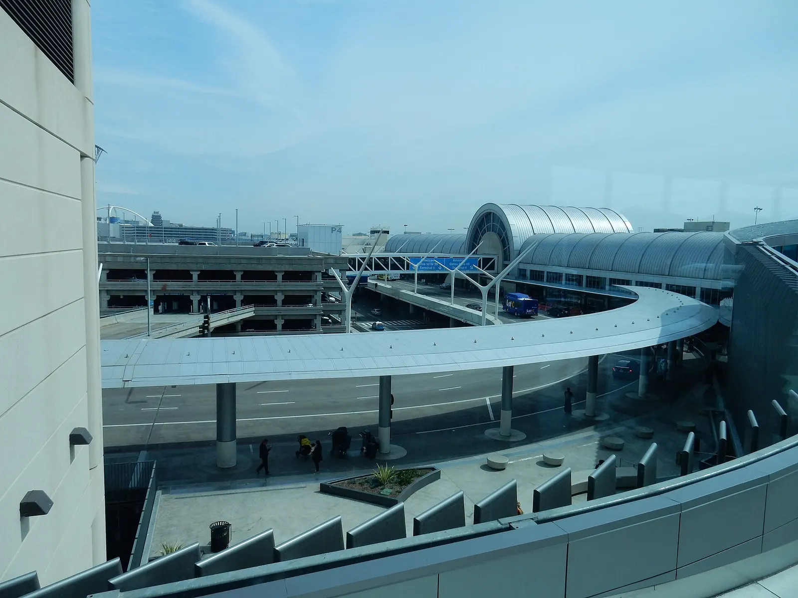 A view from inside the new Terminal 4–Tom Bradley connector walkway, showing the airfield, taxiways, and distant terminals through large windows.