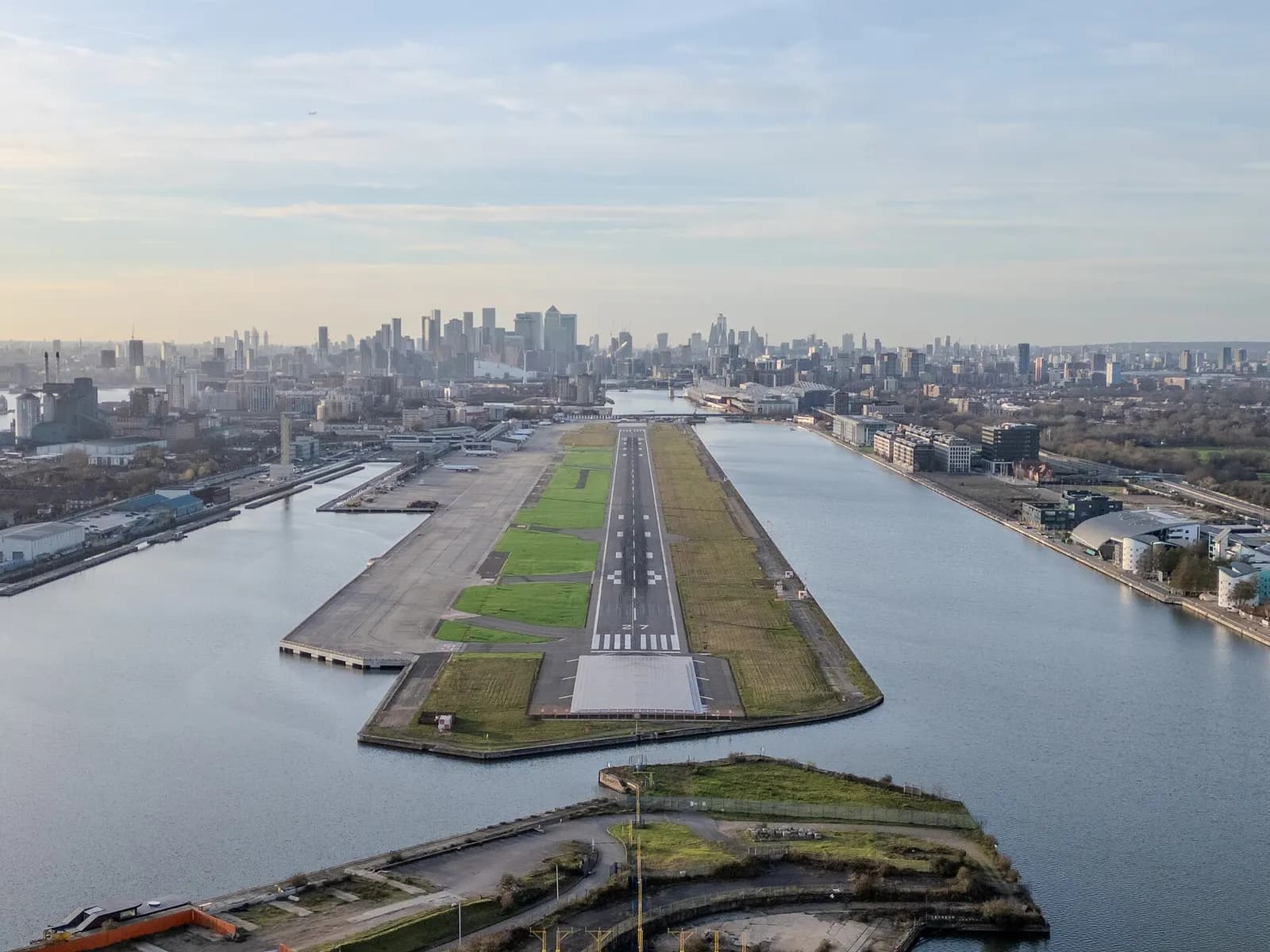 Aerial view west along London City Airport’s single runway between the Royal Docks and the Thames